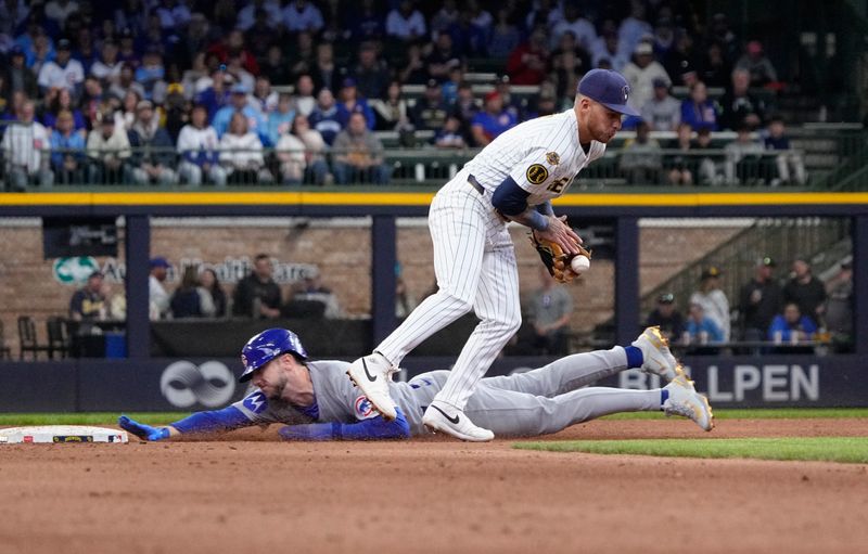 May 4, 2025; Milwaukee, Wisconsin, USA; Milwaukee Brewers second base Brice Turang (2) bobbles the ball as Chicago Cubs outfielder Kyle Tucker (30) slides safely into second base in the ninth inning at American Family Field. Mandatory Credit: Michael McLoone-Imagn Images