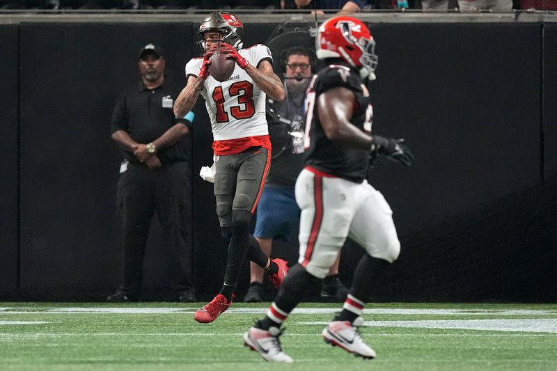 Tampa Bay Buccaneers wide receiver Mike Evans (13) makes a touchdown catch against the Atlanta Falcons during the first half of an NFL football game Thursday, Oct. 3, 2024, in Atlanta. (AP Photo/John Bazemore)