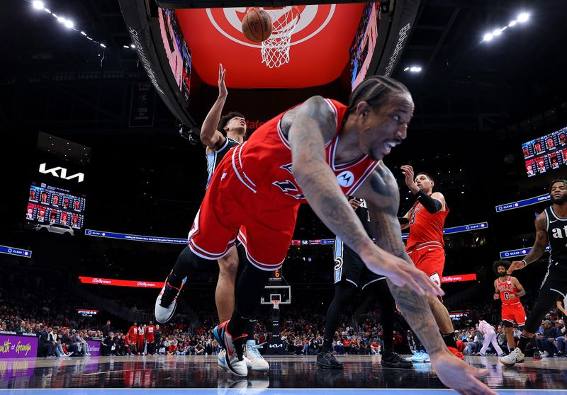 ATLANTA, GEORGIA - FEBRUARY 12:  DeMar DeRozan #11 of the Chicago Bulls falls the floor as he is fouled by Jalen Johnson #1 of the Atlanta Hawks during the second quarter at State Farm Arena on February 12, 2024 in Atlanta, Georgia.  NOTE TO USER: User expressly acknowledges and agrees that, by downloading and/or using this photograph, user is consenting to the terms and conditions of the Getty Images License Agreement.  (Photo by Kevin C. Cox/Getty Images)