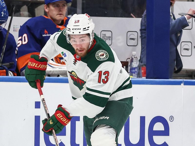 Apr 4, 2025; Elmont, New York, USA;  Minnesota Wild center Yakov Trenin (13) controls the puck in the first period against the New York Islanders at UBS Arena. Mandatory Credit: Wendell Cruz-Imagn Images