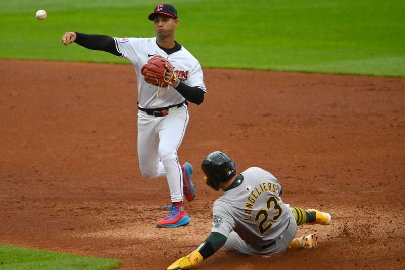 Apr 20, 2024; Cleveland, Ohio, USA; Cleveland Guardians shortstop Brayan Rocchio (4) throws to first base after forcing out Oakland Athletics catcher Shea Langeliers (23) in the second inning at Progressive Field. Mandatory Credit: David Richard-USA TODAY Sports