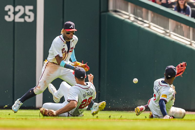 Apr 26, 2024; Cumberland, Georgia, USA; A ball hit by Cleveland Guardians third baseman Jose Ramirez (11) (not pictured) falls between Atlanta Braves right fielder Ronald Acuna Jr (13) first baseman Matt Olson (28) and second baseman Ozzie Albies (1) during the tenth inning at Truist Park. Mandatory Credit: Dale Zanine-USA TODAY Sports