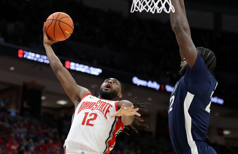 Jan 20, 2024; Columbus, Ohio, USA;  Ohio State Buckeyes guard Evan Mahaffey (12) drives to the basket as Penn State Nittany Lions forward Qudus Wahab (22) defends during the second half at Value City Arena. Mandatory Credit: Joseph Maiorana-USA TODAY Sports