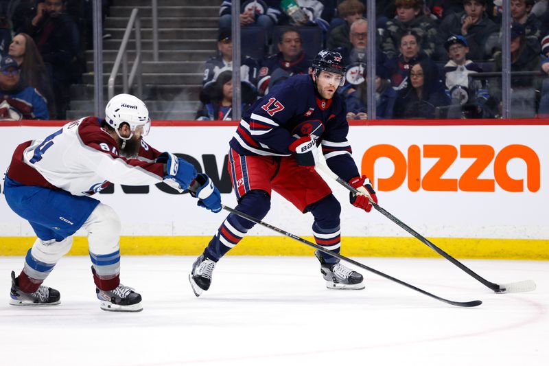 Mar 14, 2026; Winnipeg, Manitoba, CAN; Winnipeg Jets center Adam Lowry (17) is checked by Colorado Avalanche defenseman Brent Burns (84) in the second period at Canada Life Centre. Mandatory Credit: James Carey Lauder-Imagn Images