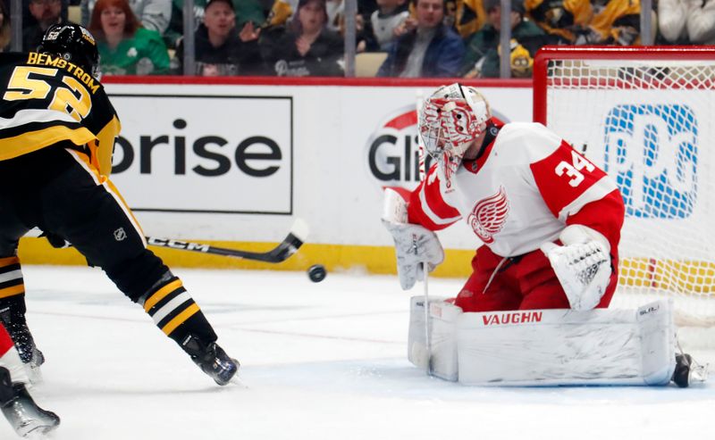 Mar 17, 2024; Pittsburgh, Pennsylvania, USA;  Detroit Red Wings goaltender Alex Lyon (34) makes a save against Pittsburgh Penguins right wing Emil Bemstrom (52) during the first period at PPG Paints Arena. Mandatory Credit: Charles LeClaire-USA TODAY Sports