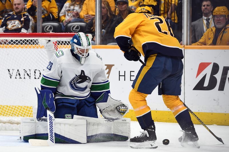 Dec 19, 2023; Nashville, Tennessee, USA; Vancouver Canucks goaltender Casey DeSmith (29) makes a save on a shot by Nashville Predators center Philip Tomasino (26) during the third period at Bridgestone Arena. Mandatory Credit: Christopher Hanewinckel-USA TODAY Sports