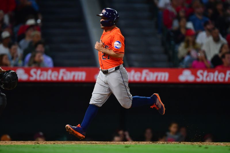 Jun 7, 2024; Anaheim, California, USA; Houston Astros second base Jose Altuve (27) scores a run against the Los Angeles Angels during the seventh inning at Angel Stadium. Mandatory Credit: Gary A. Vasquez-USA TODAY Sports