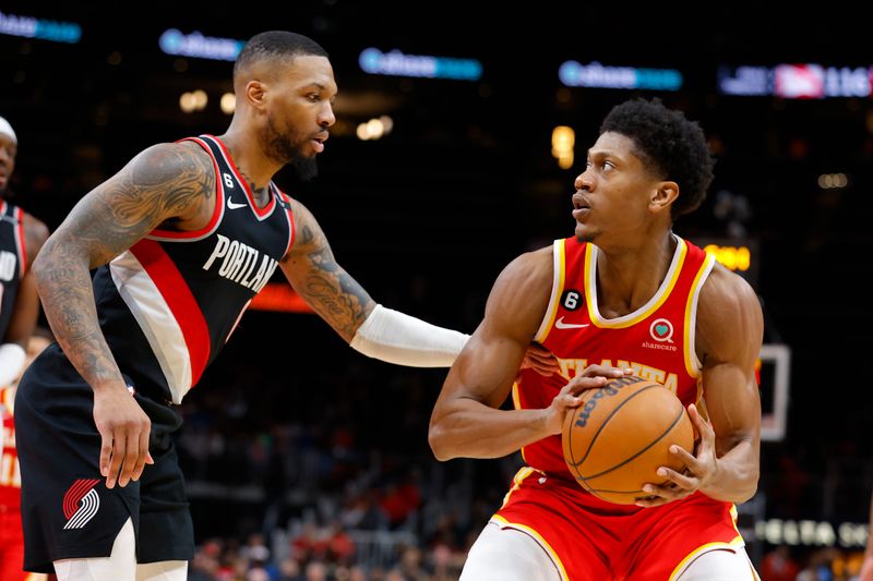 ATLANTA, GA - MARCH 03: De'Andre Hunter #12 of the Atlanta Hawks is defended by Damian Lillard #0 of the Portland Trail Blazers during the second half at State Farm Arena on March 3, 2023 in Atlanta, Georgia. NOTE TO USER: User expressly acknowledges and agrees that, by downloading and or using this photograph, User is consenting to the terms and conditions of the Getty Images License Agreement. (Photo by Todd Kirkland/Getty Images)