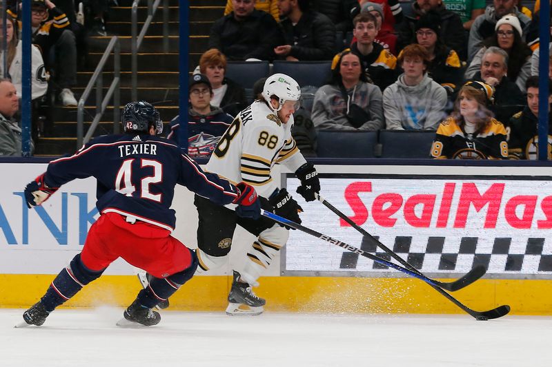 Jan 2, 2024; Columbus, Ohio, USA; Boston Bruins right wing David Pastrnak (88) carries the puck past Columbus Blue Jackets center Alexander Texier (42) during the second period at Nationwide Arena. Mandatory Credit: Russell LaBounty-USA TODAY Sports