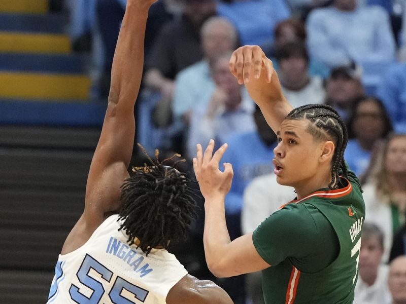 Feb 26, 2024; Chapel Hill, North Carolina, USA; Miami (Fl) Hurricanes guard Kyshawn George (7) passes the ball as North Carolina Tar Heels forward Harrison Ingram (55) defends in the second half at Dean E. Smith Center. Mandatory Credit: Bob Donnan-USA TODAY Sports