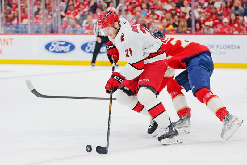 May 26, 2025; Sunrise, Florida, USA; Carolina Hurricanes defenseman Alexander Nikishin (21) moves the puck during the third period against the Florida Panthers in game four of the Eastern Conference Final of the 2025 Stanley Cup Playoffs at Amerant Bank Arena. Mandatory Credit: Sam Navarro-Imagn Images