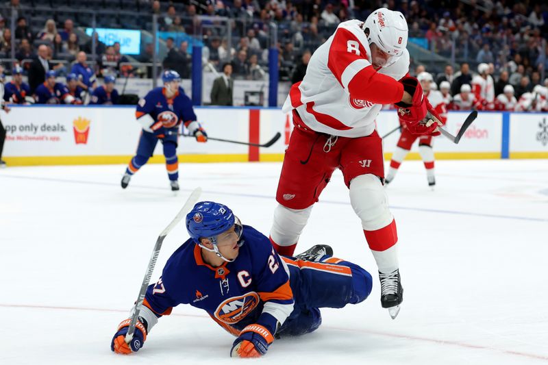 Oct 22, 2024; Elmont, New York, USA; Detroit Red Wings defenseman Ben Chiarot (8) skates against New York Islanders left wing Anders Lee (27) during the first period at UBS Arena. Mandatory Credit: Brad Penner-Imagn Images