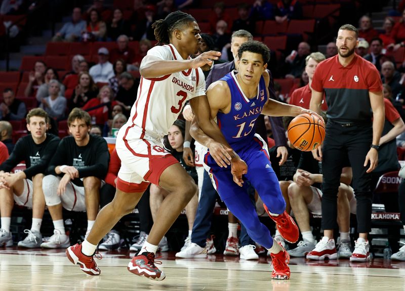 Feb 11, 2023; Norman, Oklahoma, USA; Kansas Jayhawks guard Kevin McCullar Jr. (15) drives around Oklahoma Sooners guard Otega Oweh (3) during the first half at Lloyd Noble Center. Mandatory Credit: Alonzo Adams-USA TODAY Sports