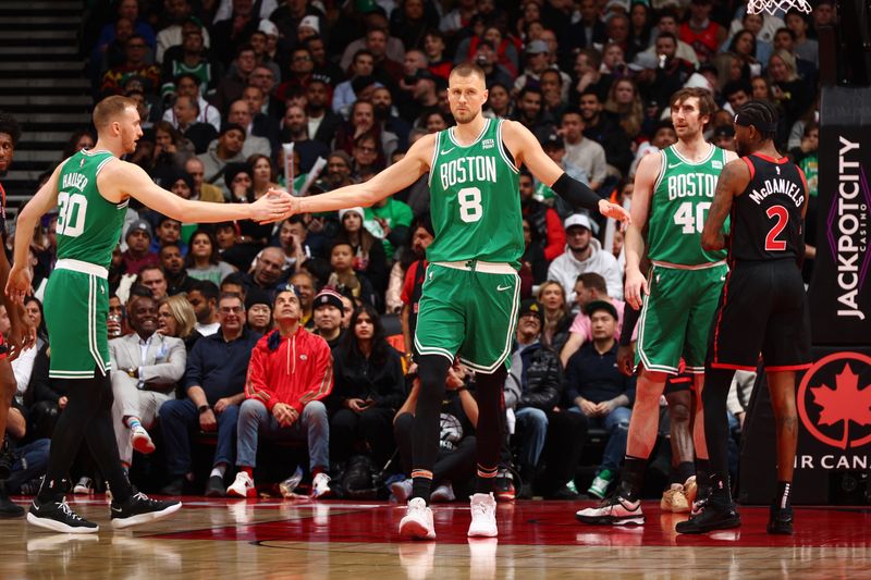 TORONTO, CANADA - JANUARY 15:  Kristaps Porzingis #8 of the Boston Celtics is congratulated during the game against the Toronto Raptors on January 15, 2024 at the Scotiabank Arena in Toronto, Ontario, Canada.  NOTE TO USER: User expressly acknowledges and agrees that, by downloading and or using this Photograph, user is consenting to the terms and conditions of the Getty Images License Agreement.  Mandatory Copyright Notice: Copyright 2024 NBAE (Photo by Vaughn Ridley/NBAE via Getty Images)