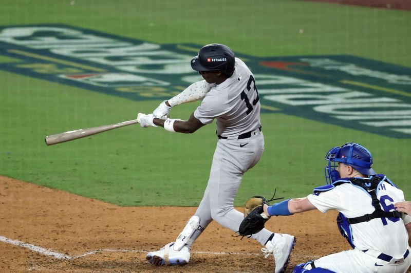 Oct 25, 2024; Los Angeles, California, USA; New York Yankees third baseman Jazz Chisholm Jr. (13) hits a single against the Los Angeles Dodgers in the tenth inning during game one of the 2024 MLB World Series at Dodger Stadium. Mandatory Credit: Kiyoshi Mio-Imagn Images