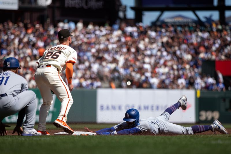 Sep 14, 2025; San Francisco, California, USA; Los Angeles Dodgers shortstop Mookie Betts (50) slides safely into third base ahead of the relay to San Francisco Giants third baseman Matt Chapman (26) during the third inning at Oracle Park. Mandatory Credit: D. Ross Cameron-Imagn Images