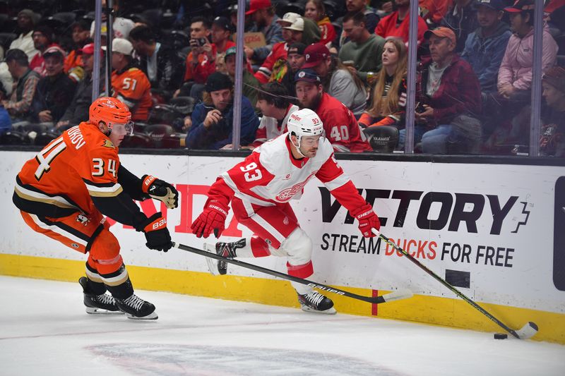 Nov 15, 2024; Anaheim, California, USA; Detroit Red Wings right wing Alex DeBrincat (93) moves the puck against Anaheim Ducks defenseman Pavel Mintyukov (34) during the first period at Honda Center. Mandatory Credit: Gary A. Vasquez-Imagn Images