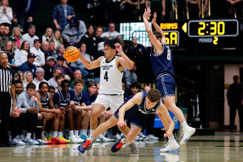 Jan 23, 2026; Fort Collins, Colorado, USA; Colorado State Rams guard Jase Butler (4) controls the ball against Utah State Aggies guard Mason Falslev (12) and guard Drake Allen (8) in the second half at Moby Arena. Mandatory Credit: Isaiah J. Downing-Imagn Images