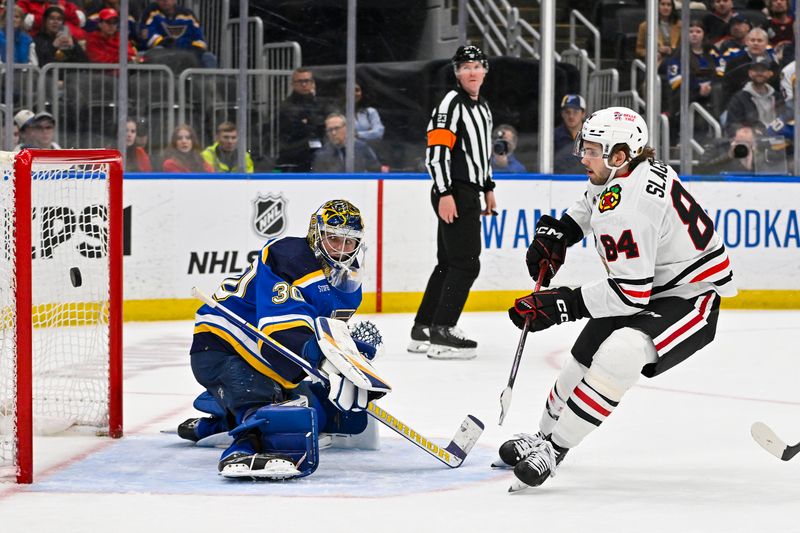 Apr 10, 2024; St. Louis, Missouri, USA;  Chicago Blackhawks left wing Landon Slaggert (84) shoots and scores his first career NHL goal against St. Louis Blues goaltender Joel Hofer (30) during the third period at Enterprise Center. Mandatory Credit: Jeff Curry-USA TODAY Sports