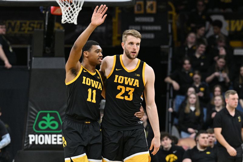 Feb 17, 2024; Iowa City, Iowa, USA; Iowa Hawkeyes guard Tony Perkins (11) and forward Ben Krikke (23) react during the second half against the Wisconsin Badgers at Carver-Hawkeye Arena. Mandatory Credit: Jeffrey Becker-USA TODAY Sports