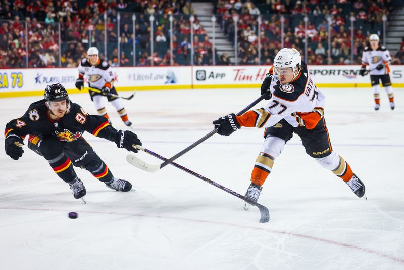 Apr 2, 2024; Calgary, Alberta, CAN; Anaheim Ducks right wing Frank Vatrano (77) shoots the puck in front of Calgary Flames defenseman Brayden Pachal (94) during the first period at Scotiabank Saddledome. Mandatory Credit: Sergei Belski-USA TODAY Sports