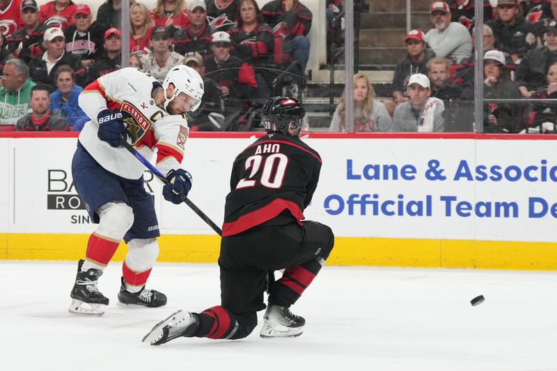 May 28, 2025; Raleigh, North Carolina, USA; Florida Panthers forward Aleksander Barkov (16) shoots the puck against Carolina Hurricanes forward Sebastian Aho (20) during the second period in game five of the Eastern Conference Final of the 2025 Stanley Cup Playoffs at Lenovo Center. Mandatory Credit: James Guillory-Imagn Images