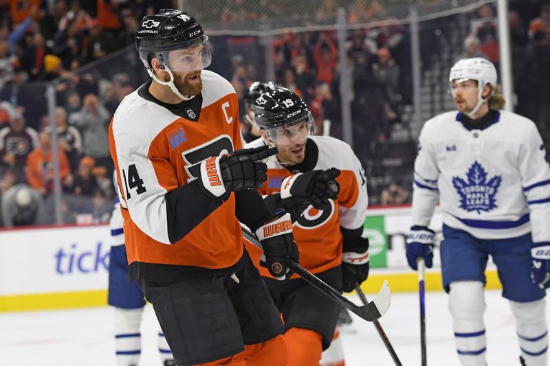 Jan 7, 2025; Philadelphia, Pennsylvania, USA; Philadelphia Flyers center Sean Couturier (14) and right wing Garnet Hathaway (19) point to Philadelphia Flyers right wing Travis Konecny (11) (not pictured) after he scored a goal against the Toronto Maple Leafs during the first period at Wells Fargo Center. Mandatory Credit: Eric Hartline-Imagn Images