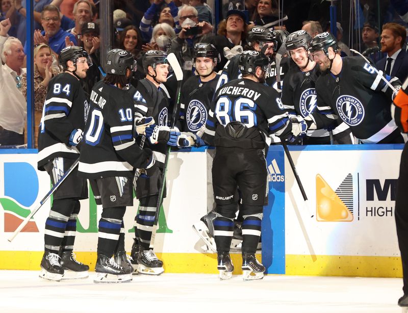 Apr 17, 2024; Tampa, Florida, USA; Tampa Bay Lightning right wing Nikita Kucherov (86) is congratulated after his 100th assist of the year on a goal by center Brayden Point (21) during the second period at Amalie Arena. Mandatory Credit: Kim Klement Neitzel-USA TODAY Sports