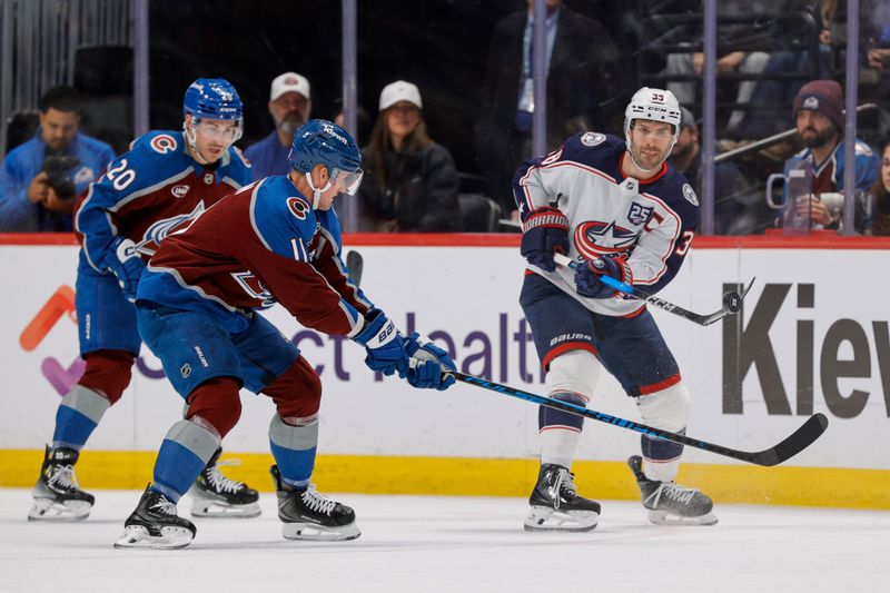 Jan 10, 2026; Denver, Colorado, USA; Columbus Blue Jackets center Boone Jenner (38) plays the puck forward ahead of Colorado Avalanche center Brock Nelson (11) and center Ross Colton (20) in the first period at Ball Arena. Mandatory Credit: Isaiah J. Downing-Imagn Images