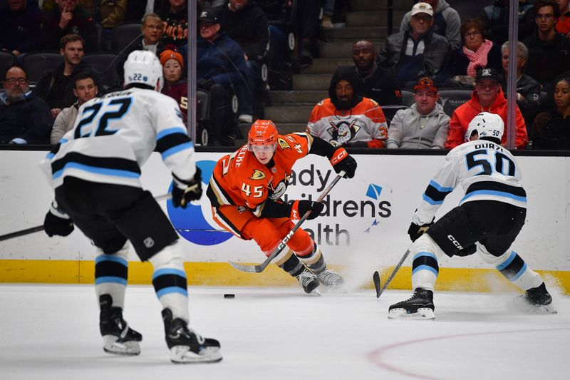 Dec 3, 2025; Anaheim, California, USA; Anaheim Ducks right wing Beckett Sennecke (45) moves the puck against Utah Mammoth defeseman Sean Durzi (50) during the first period at Honda Center. Mandatory Credit: Gary A. Vasquez-Imagn Images