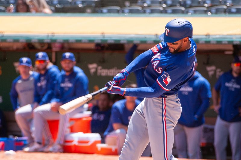 May 7, 2024; Oakland, California, USA; Texas Rangers outfielder Leody Taveras (3) hits an rbi single against the Oakland Athletics during the second inning at Oakland-Alameda County Coliseum. Mandatory Credit: Ed Szczepanski-USA TODAY Sports