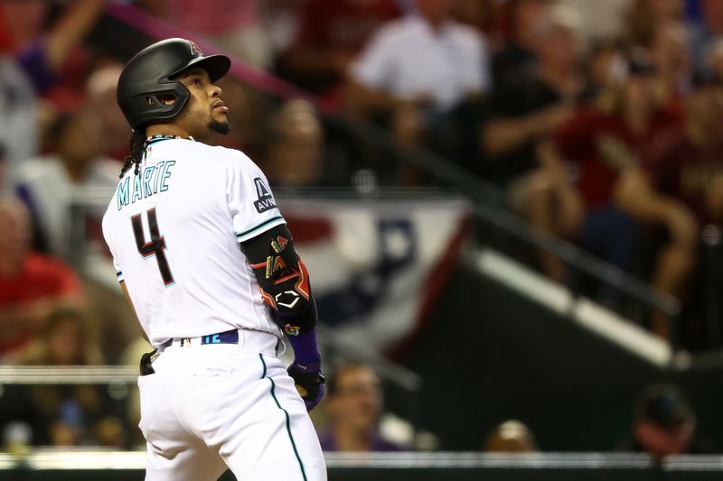 Oct 11, 2023; Phoenix, Arizona, USA; Arizona Diamondbacks second baseman Ketel Marte (4) hits a home run against the Los Angeles Dodgers in the third inning for game three of the NLDS for the 2023 MLB playoffs at Chase Field. Mandatory Credit: Mark J. Rebilas-USA TODAY Sports