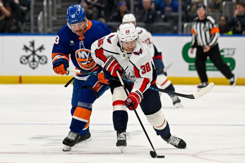 Nov 30, 2025; Elmont, New York, USA;  38 skates with the puck chased by New York Islanders center Casey Cizikas (53) during the second period at UBS Arena. Mandatory Credit: Dennis Schneidler-Imagn Images