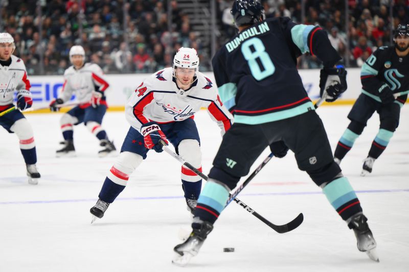 Mar 14, 2024; Seattle, Washington, USA; Washington Capitals center Connor McMichael (24) defends Seattle Kraken defenseman Brian Dumoulin (8) during the first period at Climate Pledge Arena. Mandatory Credit: Steven Bisig-USA TODAY Sports