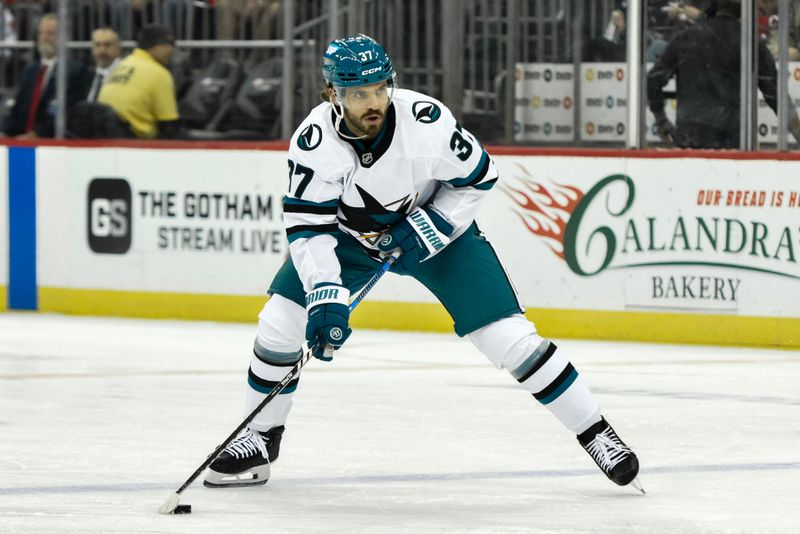 Nov 10, 2024; Newark, New Jersey, USA; San Jose Sharks defenseman Timothy Liljegren (37) skates with the puck against the New Jersey Devils during the first period at Prudential Center. Mandatory Credit: John Jones-Imagn Images