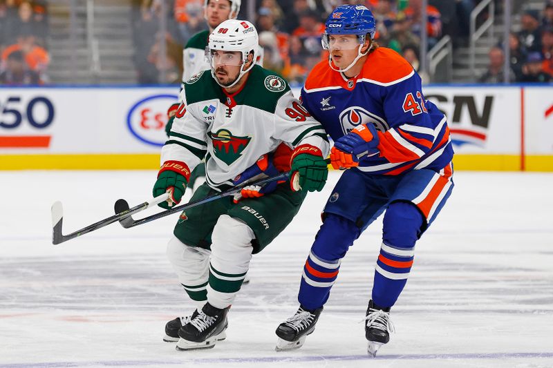 Nov 21, 2024; Edmonton, Alberta, CAN; Edmonton Oilers forward Kasperi Kapanen (42) and Minnesota Wild forward Marcus Johansson (90) look for a loose puck during the second period at Rogers Place. Mandatory Credit: Perry Nelson-Imagn Images