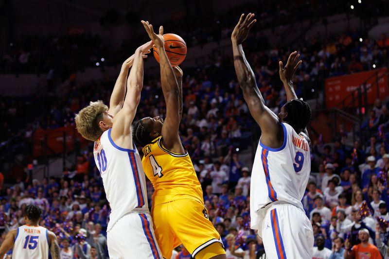 Jan 14, 2025; Gainesville, Florida, USA; Florida Gators forward Thomas Haugh (10) attempts to block a shot from Missouri Tigers guard Marcus Allen (4) while Florida Gators center Rueben Chinyelu (9) also defends during the first half at Exactech Arena at the Stephen C. O'Connell Center. Mandatory Credit: Matt Pendleton-Imagn Images