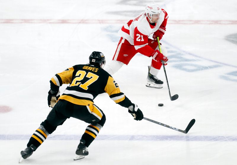 Mar 17, 2024; Pittsburgh, Pennsylvania, USA;  Detroit Red Wings center Austin Czarnik (21) moves the puck against Pittsburgh Penguins defenseman Ryan Graves (27) during the third period at PPG Paints Arena. Pittsburgh won 6-3. Mandatory Credit: Charles LeClaire-USA TODAY Sports