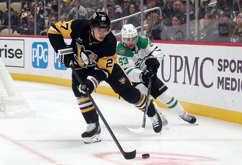 Nov 11, 2024; Pittsburgh, Pennsylvania, USA;  Pittsburgh Penguins defenseman Ryan Graves (27) moves the puck as Dallas Stars right wing Evgenii Dadonov (63) chases during the second period at PPG Paints Arena. Mandatory Credit: Charles LeClaire-Imagn Images