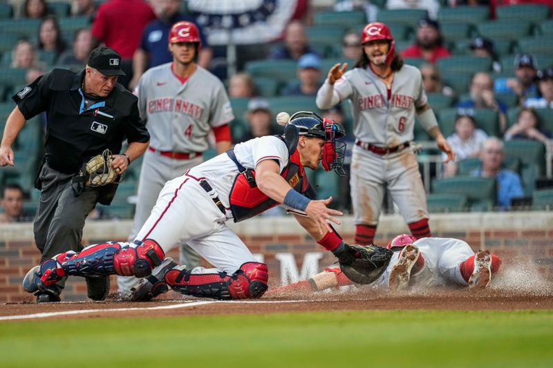 Apr 12, 2023; Cumberland, Georgia, USA; Cincinnati Reds center fielder TJ Friedl (29) dives into home plate behind Atlanta Braves catcher Sean Murphy (12) to score a run during the first inning at Truist Park. Mandatory Credit: Dale Zanine-USA TODAY Sports