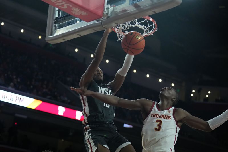 Jan 10, 2024; Los Angeles, California, USA; Washington State Cougars forward Isaac Jones (13) dunks the ball against Southern California Trojans forward Vincent Iwuchukwu (3) in the first half at Galen Center. Mandatory Credit: Kirby Lee-USA TODAY Sports