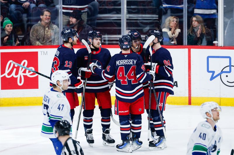 Jan 14, 2025; Winnipeg, Manitoba, CAN;  Winnipeg Jets forward Mark Scheifele (55) celebrates with teammates after scoring a goal against the Vancouver Canucks during the third period at Canada Life Centre. Mandatory Credit: Terrence Lee-Imagn Images