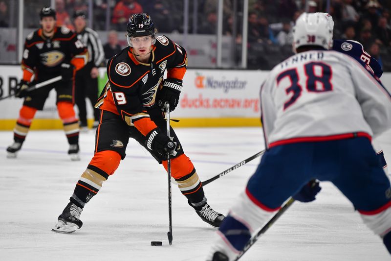 Feb 21, 2024; Anaheim, California, USA; Anaheim Ducks right wing Troy Terry (19) moves the puck against Columbus Blue Jackets center Boone Jenner (38) during the first period at Honda Center. Mandatory Credit: Gary A. Vasquez-USA TODAY Sports