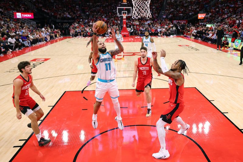 HOUSTON, TEXAS - OCTOBER 23: Cody Martin #11 of the Charlotte Hornets shoots against Jalen Green #4 of the Houston Rockets during the first half at Toyota Center on October 23, 2024 in Houston, Texas.  NOTE TO USER: User expressly acknowledges and agrees that, by downloading and or using this photograph, User is consenting to the terms and conditions of the Getty Images License Agreement. (Photo by Alex Slitz/Getty Images)