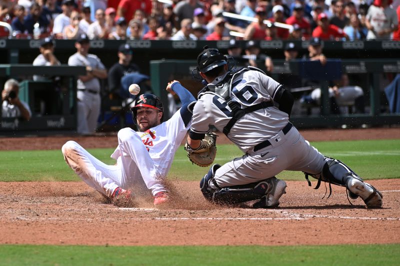 Jul 2, 2023; St. Louis, Missouri, USA; St. Louis Cardinals center fielder Dylan Carlson (3) is safe at home plate ahead of the tag from New York Yankees catcher Kyle Higashioka (66) in the eight inning at Busch Stadium. Mandatory Credit: Joe Puetz-USA TODAY Sports