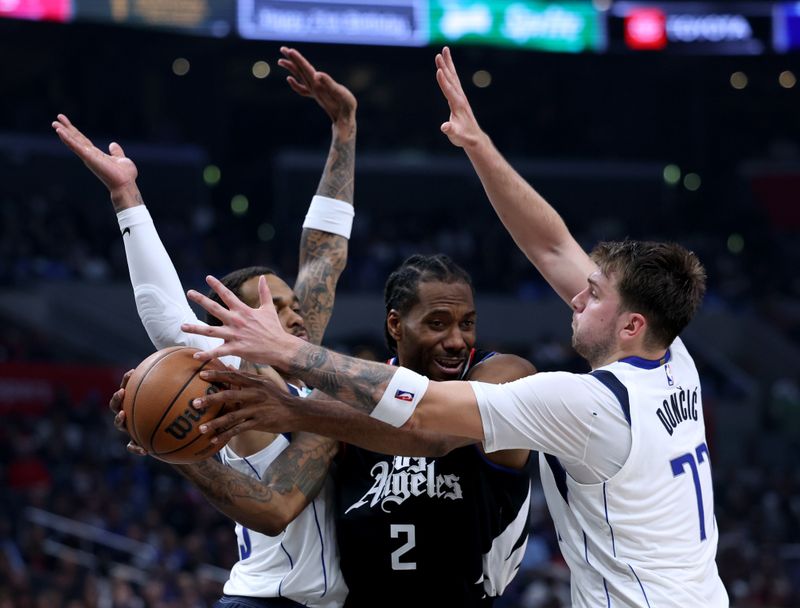 LOS ANGELES, CALIFORNIA - APRIL 23: Kawhi Leonard #2 of the LA Clippers looks to pass out of a trap by Luka Doncic #77 and P.J. Washington #25 of the Dallas Mavericks during the first half at Crypto.com Arena on April 23, 2024 in Los Angeles, California. User is consenting to the terms and conditions of the Getty Images License Agreement. (Photo by Harry How/Getty Images)