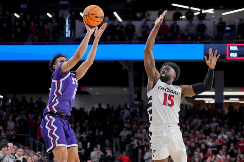 Jan 16, 2024; Cincinnati, Ohio, USA;  TCU Horned Frogs guard Trevian Tennyson (11) attempts a three-point basket against Cincinnati Bearcats forward John Newman III (15) in the second half at Fifth Third Arena. Mandatory Credit: Aaron Doster-USA TODAY Sports