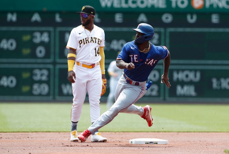 May 24, 2023; Pittsburgh, Pennsylvania, USA; Texas Rangers right fielder Adolis Garcia (right) runs from first base to third base against the Pittsburgh Pirates during the first inning at PNC Park. Mandatory Credit: Charles LeClaire-USA TODAY Sports