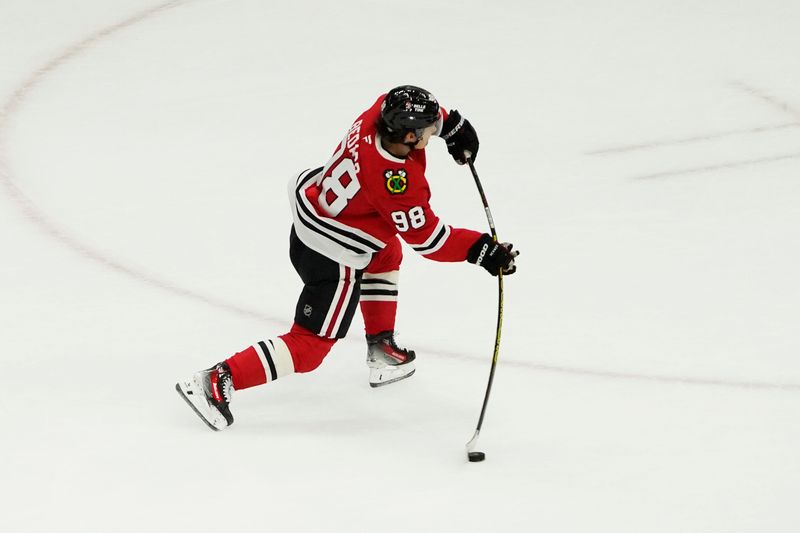 Oct 22, 2024; Chicago, Illinois, USA; Chicago Blackhawks center Connor Bedard (98) shoots the puck against the Vancouver Canucks during the second period at United Center. Mandatory Credit: David Banks-Imagn Images