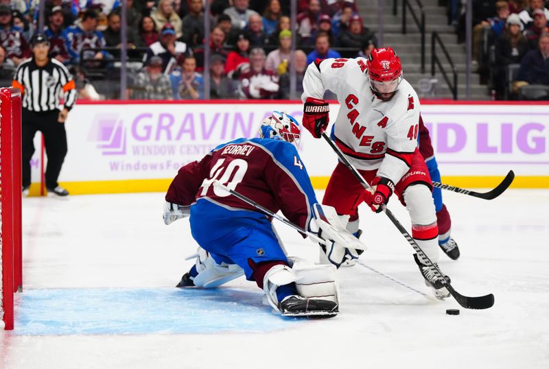 Nov 9, 2024; Denver, Colorado, USA; Colorado Avalanche goaltender Alexandar Georgiev (40) and makes a save on Carolina Hurricanes left wing Jordan Martinook (48) the third period at Ball Arena. Mandatory Credit: Ron Chenoy-Imagn Images